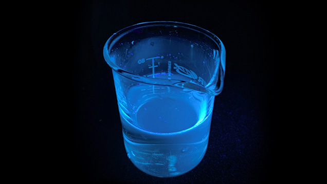 Blue fluorescence emitted by optical brightener solution Blue fluorescence emitted by optical brightener solution