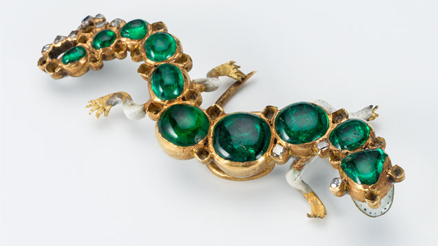 このサンショウウオの形をしたエナメルゴールドの帽子飾りは、チープサイドの財宝の最も象徴的な品物の一つである。 前面のエナメルは、歯に似せた小さな黒い斑点のある開いた口を表している。 ピンはコロンビア産のカボション・エメラルドで飾られ、尾はテーブルカット・ダイヤモンドがセットされている。