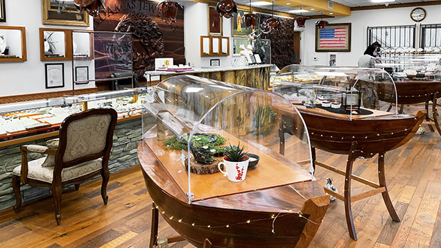 Figure 1. A look inside Adamas Jewelers in San Dimas, California, operated by Chi Huynh and his brother Kiet. The store carries Galatea’s jewelry and is decorated with Huynh’s wood carvings and paintings, including the boat-style showcases inspired by the family’s journey from Vietnam. Photo by Tao Hsu. Figure 1. A look inside Adamas Jewelers in San Dimas, California, operated by Chi Huynh and his brother Kiet. The store carries Galatea’s jewelry and is decorated with Huynh’s wood carvings and paintings, including the boat-style showcases inspired by the family’s journey from Vietnam. Photo by Tao Hsu.