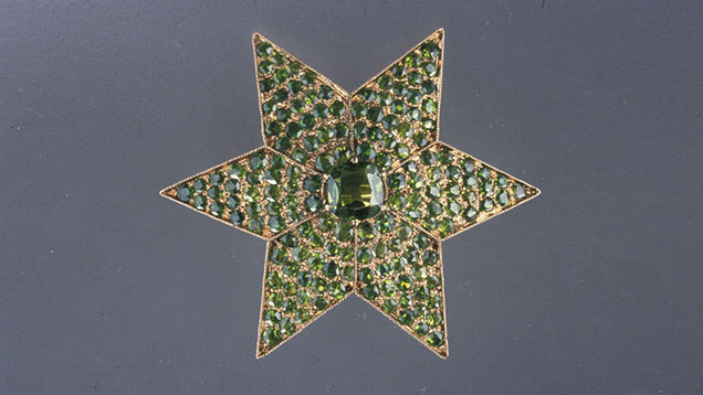 Demantoid garnets provide a field of green for this antique star brooch manufactured in Russia. Demantoid garnets were popular in Russian jewelry from 1875 to 1920. Courtesy of A La Vielle Russie, New York City; photo by Nicholas Del Re © GIA