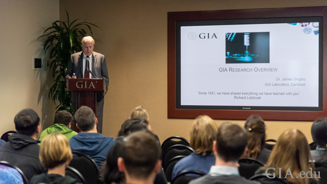 Man stands at a podium in front of a room of people.
