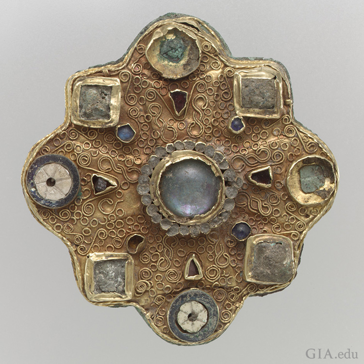 Frankish disk brooch from the second half 7th century. Medium: Gold sheet, filigree, moonstone/adularia, glass cabochons, garnets, mother-of-pearl, and moonstone. Courtesy: The Metropolitan Museum of Art