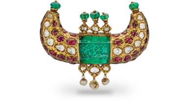 This gold pendant features a 125 carat Colombian emerald engraved in Arabic with  salutations of peace. Set with diamonds, Burmese rubies, emerald beads and dangling pearls, it was made for a ruler of the Kingdom of Mysore. Mughal Era • Mysore • 18th century • emerald, ruby, diamond and pearl in 22K gold • 6 x 8.5 x 2 cm