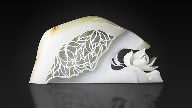 White nephrite Buddhist carving featuring openwork papercut-style and a carved lotus. White nephrite Buddhist carving featuring openwork papercut-style and a carved lotus.