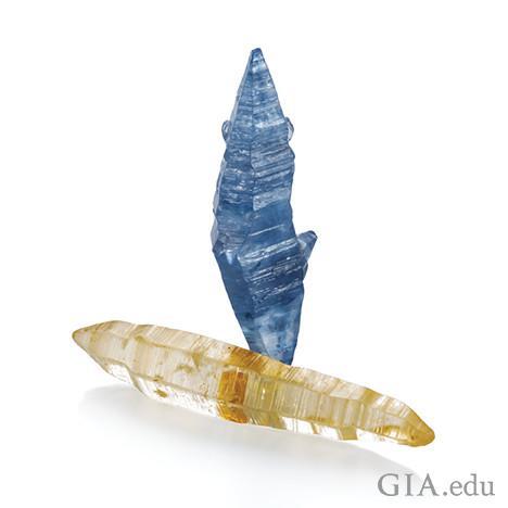 图片中显示了两个蓝宝石晶体，一个为蓝色，另一个为黄白色。