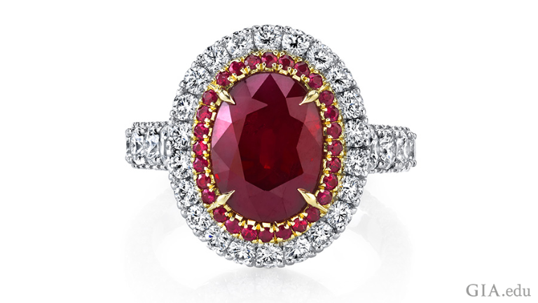 A 5 carat oval ruby is the focal point of a ring set in platinum with 18k rose gold, surrounded by halos of round rubies and diamonds.