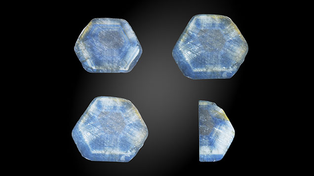 Figure 1. Each of these trapiche-like sapphires from Changle, Shandong Province, has a brown-black hexagonal core in the center and six white radiating arms. Three of the four sample slices weigh ~3.1 ct with a thickness of ~2.1 mm; the sample slice on the bottom right weighs ~0.7 ct with a thickness of ~1 mm. Photos by Suqin Xia.