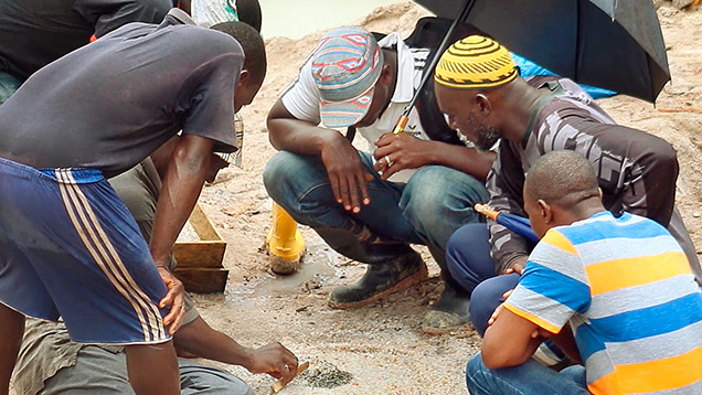 Figure 2. Miners sorting through gem gravel. Courtesy of Diamonds for Peace.