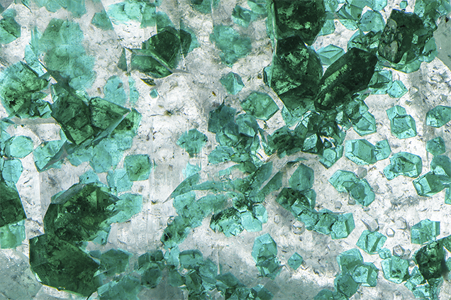 Trigonal blue-green dioptase crystals in and on quartz.