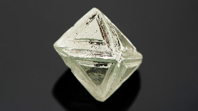 Synthetic moissanite crystal carved to resemble a natural diamond rough.