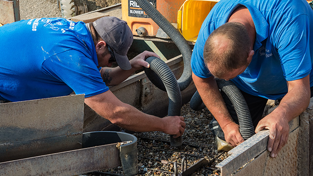 Men vacuuming dirt in the jig