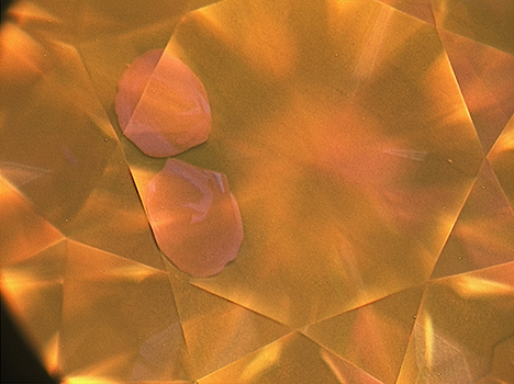 DiamondView image of pink diamond showing two pink spots near the edge of the table facet