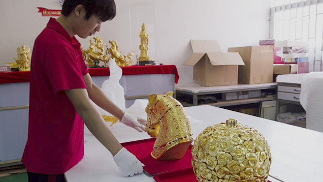 Chinese worker with gold statue Chinese worker with gold statue