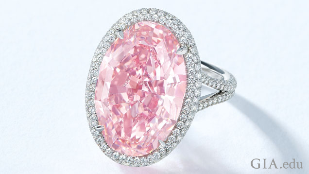 A 14.93 ct oval pink diamond is surrounded by a halo of colorless diamonds and mounted into a ring. A 14.93 ct oval pink diamond is surrounded by a halo of colorless diamonds and mounted into a ring.