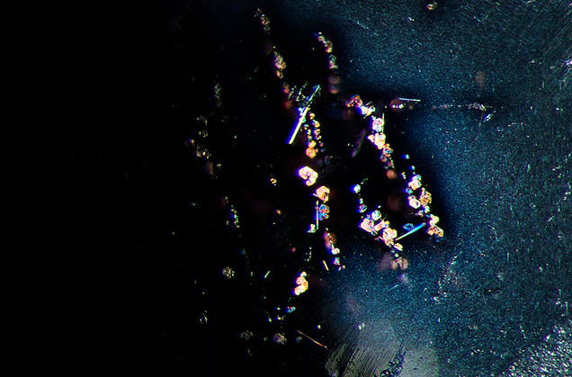 In the center of the image larger reflective platelet inclusions are visible. In the center of the image larger reflective platelet inclusions are visible.