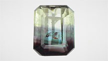 Figure 1. This 0.73 ct octagonal step cut was composed of chrysoberyl and alexandrite. The alexandrite portion showed a color change from blue-green in fluorescent light to red-purple in incandescent light. Photos by Shunsuke Nagai.