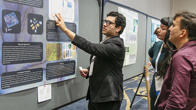 Figure 2. Jeffrey Hernandez interprets the distinctive absorption peaks of Sterling synthetic opal to show how these features allow gemologists to identify this material. Photo by Emily Lane.