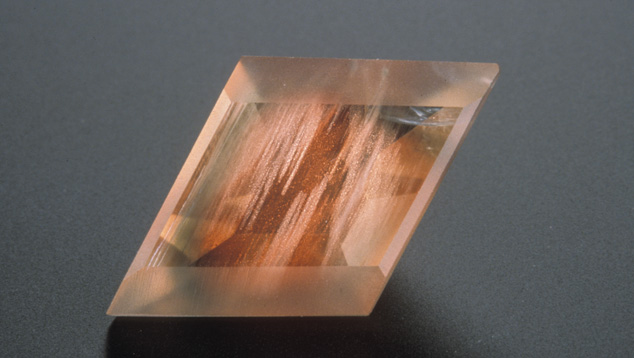 This Oregon sunstone (about 2 cm across) has been fashioned with some matte-finished facets to bring out the appearance of the copper inclusions. – Maha Tannous, courtesy Klaus Schafer