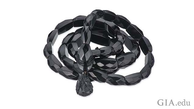 A bracelet of black jet beads on a coiled elastic to resemble a snake.