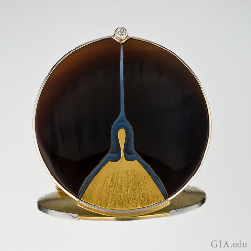 A sardonyx picture brooch with gold and platinum has a single diamond on top, showing off the August birthstone. A sardonyx picture brooch with gold and platinum has a single diamond on top, showing off the August birthstone.