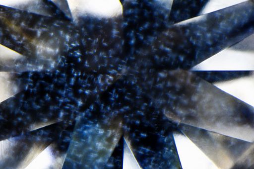 Photomicrograph of a 0.62 carat diamond showing a delicate, interlinked cross-shaped cloud inclusion pattern—an unusual structure not previously observed in GIA laboratories; field of view 2.40 mm.
