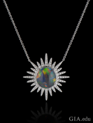 A 6.15 ct black opal in the center with 1.37 cts of diamonds radiating out in a starburst pattern. Set in 18kt white gold. A 6.15 ct black opal in the center with 1.37 cts of diamonds radiating out in a starburst pattern. Set in 18kt white gold.